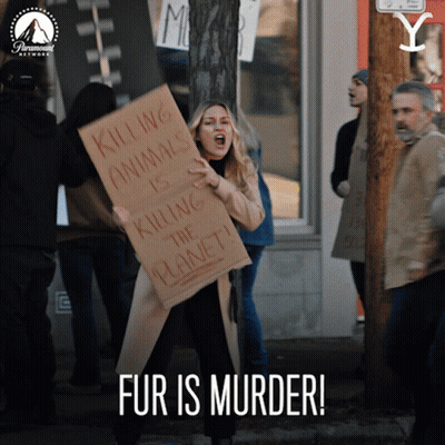 A Woman Holds A Sign That Says Killing Animals Is Killing The Planet GIF