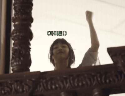 A Woman Holds Her Fist Up In The Air With A Green Sticker That Says ' I ' On It GIF