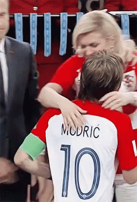 A Woman Hugging A Soccer Player With The Number 10 On His Shirt GIF