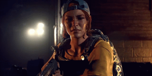 A Woman In A Baseball Cap Is Holding A Gun In Her Hand . GIF