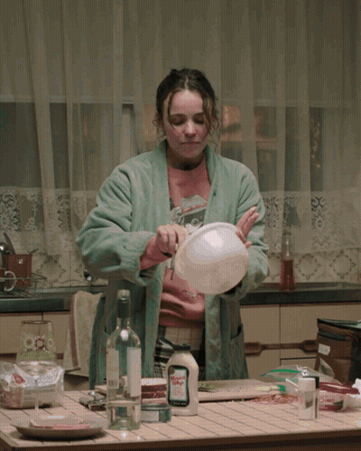 A Woman In A Bathrobe Is Washing Dishes In A Kitchen With A Bottle Of Mayonnaise On The Counter GIF