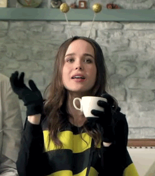 A Woman In A Bee Costume Holds A Cup Of Coffee GIF
