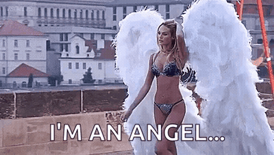 A Woman In A Bikini And Angel Wings Is Standing On A Bridge . GIF