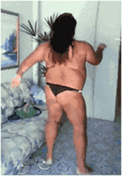 A Woman In A Bikini Is Dancing In A Living Room GIF