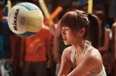 A Woman In A Bikini Is Playing Volleyball With A Mikasa Volleyball In The Background . GIF
