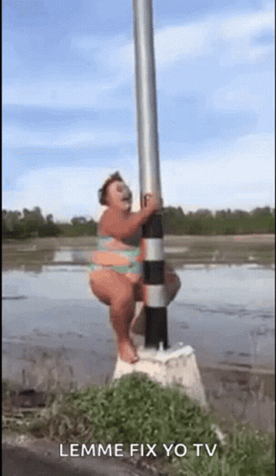 A Woman In A Bikini Is Sitting On A Pole In The Water . GIF