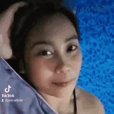 A Woman In A Bikini Is Standing In Front Of A Blue Pool . GIF