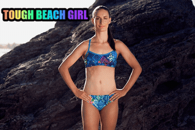 A Woman In A Bikini Is Standing In Front Of A Large Rock With The Words Tough Beach Girl Above Her GIF