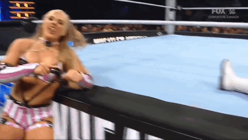 A Woman In A Bikini Is Wrestling Another Woman In A Ring . GIF