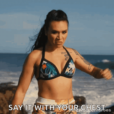 A Woman In A Bikini Says " Say It With Your Chest " In Front Of The Ocean GIF