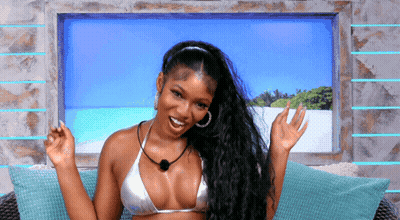 A Woman In A Bikini Sits On A Couch GIF