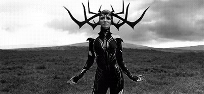 A Woman In A Black And White Photo Is Standing In A Field With Her Arms Outstretched . GIF