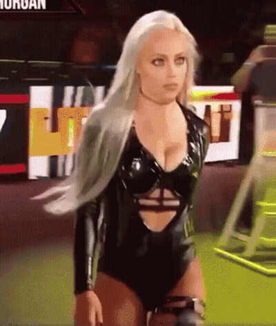 A Woman In A Black Bodysuit Is Standing In Front Of A Sign That Says ' Morgan ' On It GIF