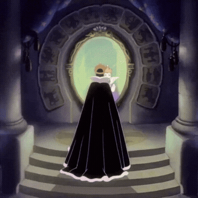 A Woman In A Black Cape Stands In Front Of A Mirror With A Crown On Her Head GIF