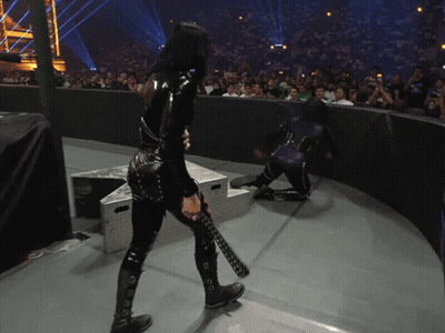 A Woman In A Black Catsuit Is Holding A Sword GIF