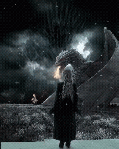 A Woman In A Black Coat Stands In Front Of A Large Dragon With A Throne In The Background GIF