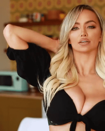 A Woman In A Black Crop Top Has Her Arm Behind Her Head GIF