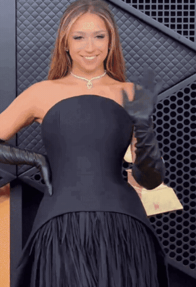 A Woman In A Black Dress And Black Gloves GIF