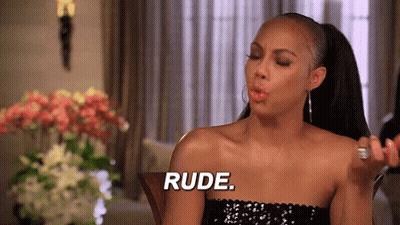 A Woman In A Black Dress Is Blowing A Kiss And Saying " Rude " GIF
