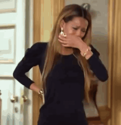 A Woman In A Black Dress Is Covering Her Face With Her Hand . GIF