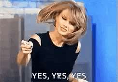 A Woman In A Black Dress Is Dancing And Holding A Cell Phone . GIF