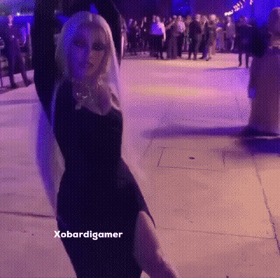 A Woman In A Black Dress Is Dancing In Front Of A Crowd And The Caption Says Xobardigmer GIF