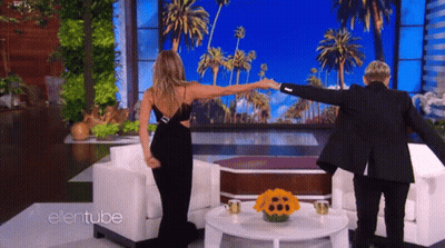 A Woman In A Black Dress Is Dancing With A Man In A Black Suit On The Ellentube Show GIF