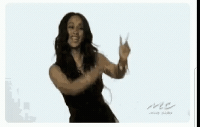 A Woman In A Black Dress Is Dancing With Her Arms Outstretched GIF