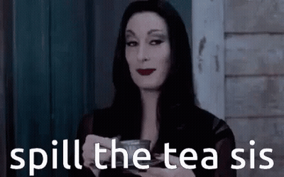 A Woman In A Black Dress Is Holding A Cup Of Tea . GIF