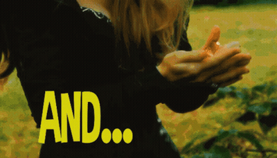 A Woman In A Black Dress Is Holding Something In Her Hands And The Word And Is Visible In Yellow GIF