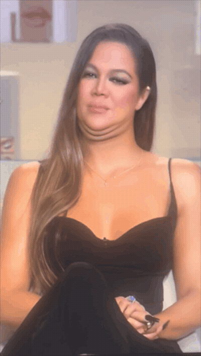 A Woman In A Black Dress Is Making A Funny Face With Her Mouth Open GIF