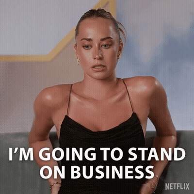 A Woman In A Black Dress Is Sitting On A Couch And Says I 'M Going To Stand On Business GIF