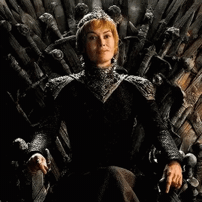 A Woman In A Black Dress Is Sitting On A Wooden Throne . GIF