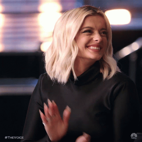 A Woman In A Black Dress Is Smiling And Applauding With The Hashtag #Thevoice GIF