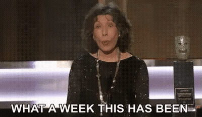 A Woman In A Black Dress Is Standing In Front Of A Microphone . GIF