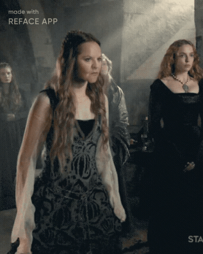 A Woman In A Black Dress Is Standing In Front Of A Sign That Says " Made With Reface App " GIF
