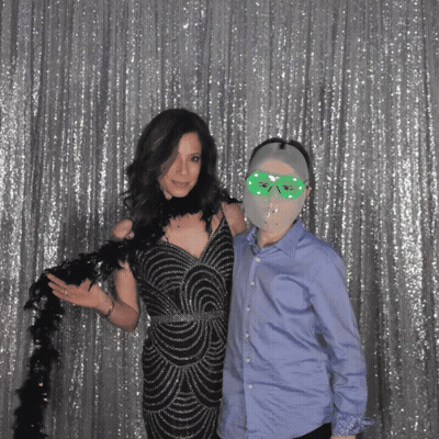 A Woman In A Black Dress Is Standing Next To A Boy Wearing A Mask GIF