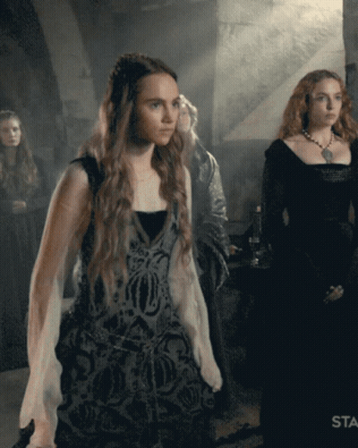 A Woman In A Black Dress Is Standing Next To A Woman In A White Dress GIF