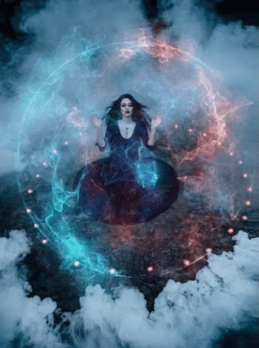 A Woman In A Black Dress Is Surrounded By Smoke GIF