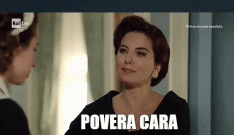 A Woman In A Black Dress Is Talking To Another Woman In A Room And The Woman Is Smiling . GIF