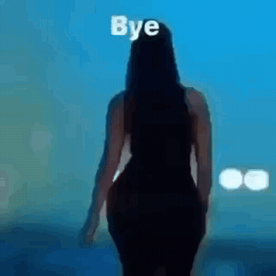 A Woman In A Black Dress Is Walking In Front Of A Screen With The Words `` Bye '' Written On It . GIF