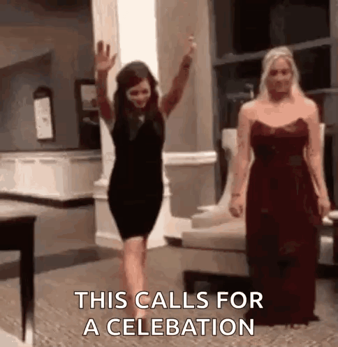 A Woman In A Black Dress Is Waving Her Hand While Another Woman In A Red Dress Is Standing Next To Her . GIF