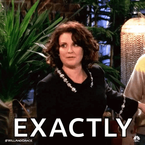 A Woman In A Black Dress Says Exactly In Front Of A Greenhouse GIF