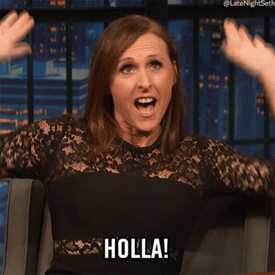 A Woman In A Black Dress Says Holla With Her Mouth Open GIF