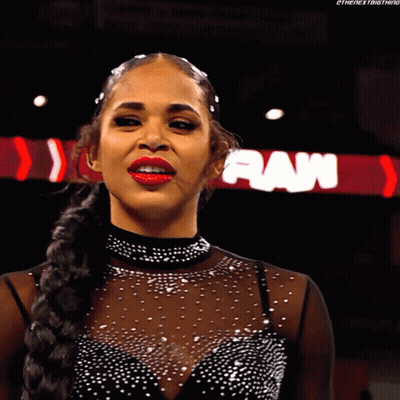A Woman In A Black Dress Stands In Front Of A Raw Sign GIF