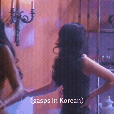 A Woman In A Black Dress Stands In Front Of A Wall With The Words Gasps In Korean GIF