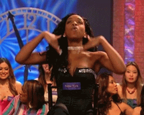 A Woman In A Black Dress With A Tag That Says New York On It GIF