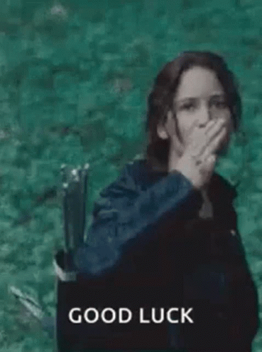 A Woman In A Black Jacket Is Giving A High Five In Front Of A Body Of Water . GIF