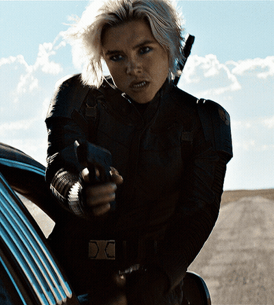 A Woman In A Black Jacket Is Pointing A Gun At Someone GIF