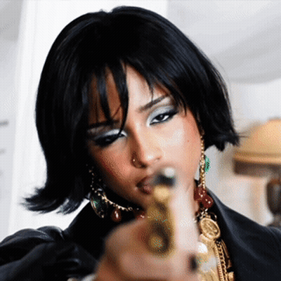 A Woman In A Black Jacket Is Pointing A Gun GIF